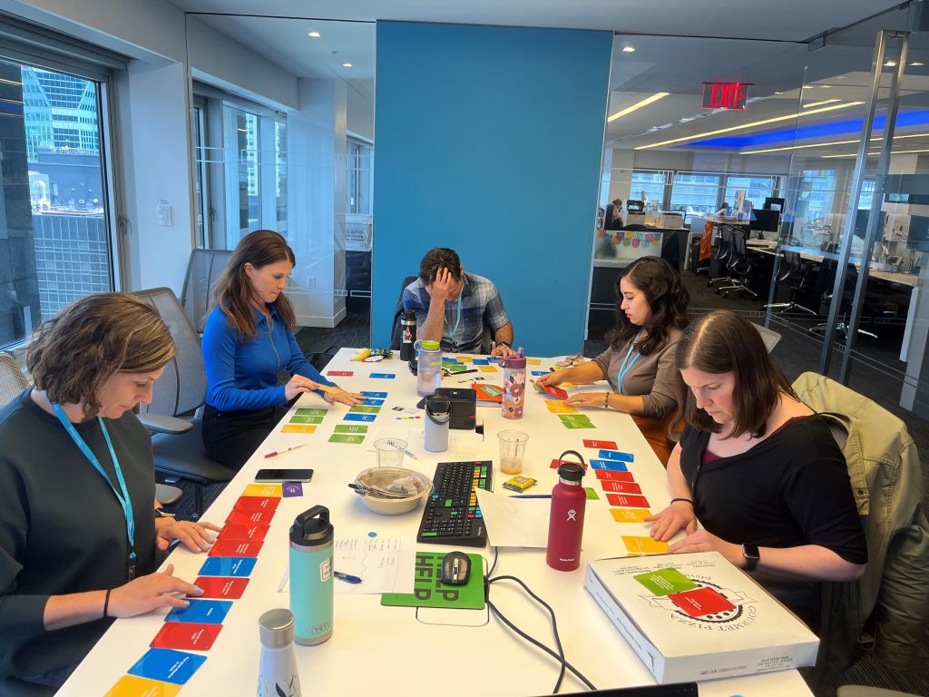 Colleagues sitting at a table together working on their insights discovery profiles.
